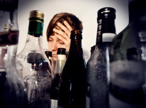 Distress person behind a bunch of bottles wondering about the alcohol detox timeline