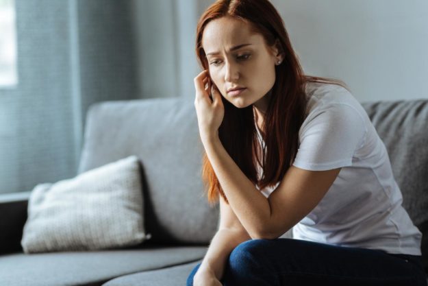 woman sitting on couch experiencing the long term effects of drug abuse
